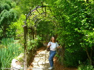 Sandy_posing_by_climbing_rose_arbor.JPG