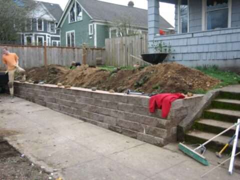 putting-in-a-concrete-retaining-wall there are many different retaining wall options including the use of medium size blocks